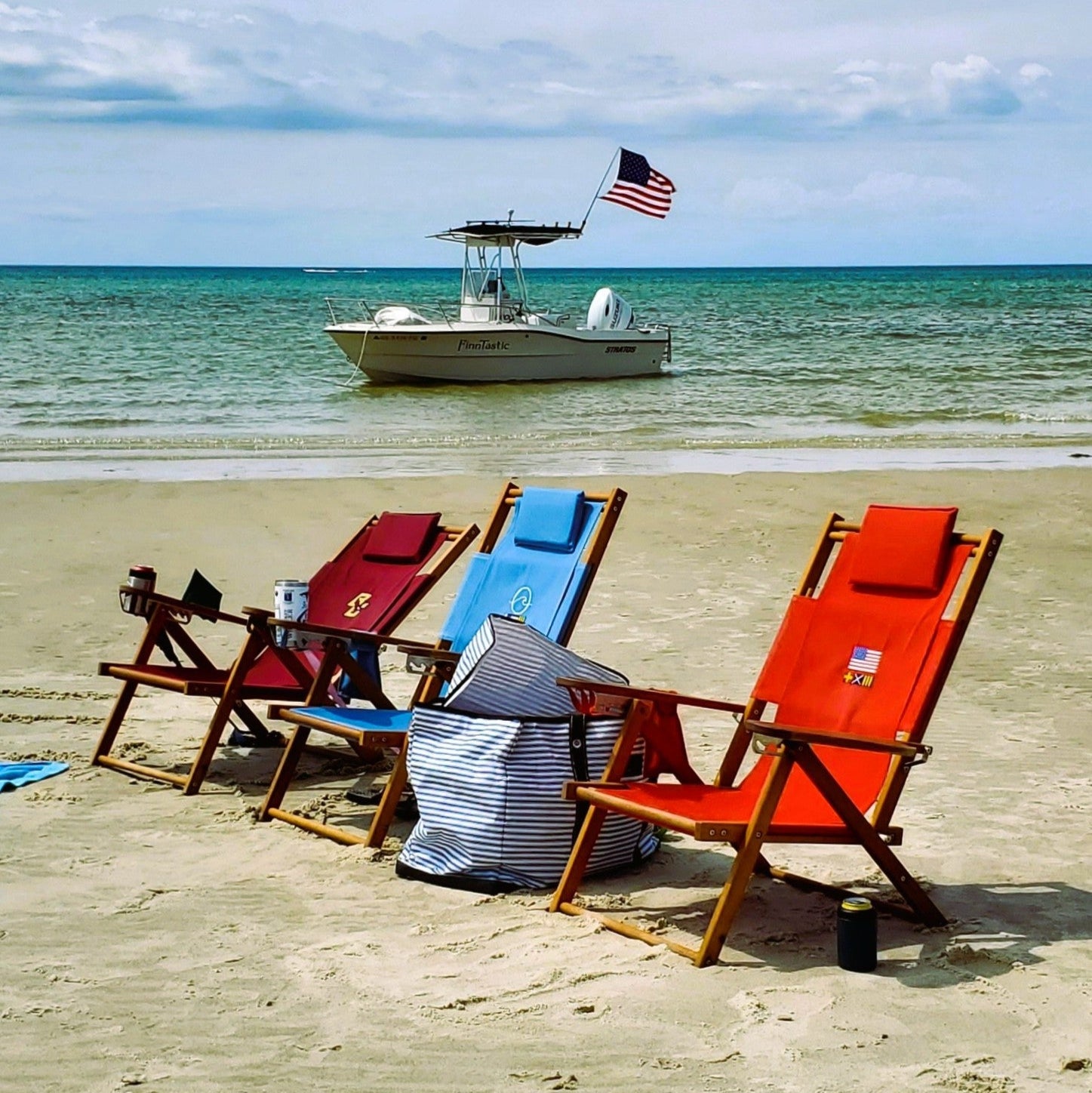 Three Custom Embroidered Wood Beach Chairs on Sand in Front of Boat in Cape Cod Bay
