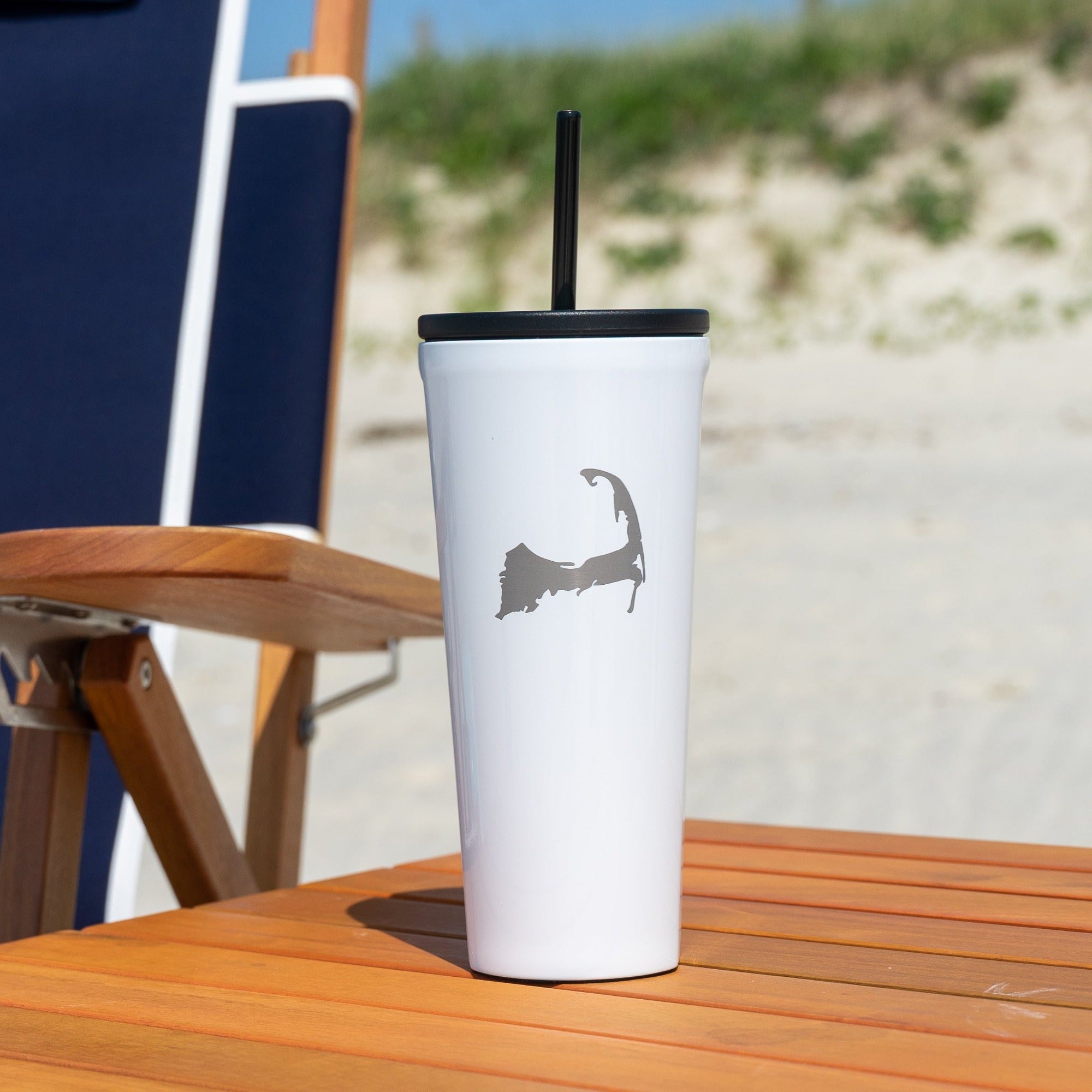 White cape cod insulated cup on wood beach table