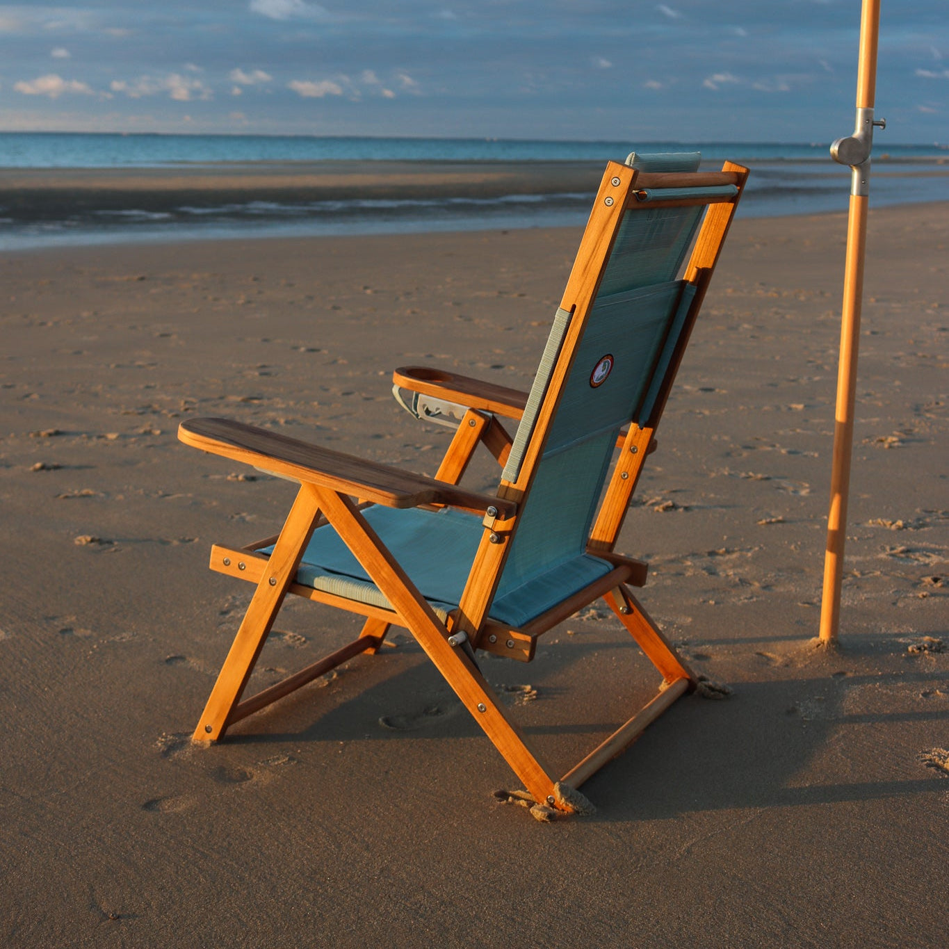 Premium teak wood seafoam beach chair on cape cod beach at sunset under beach umbrella