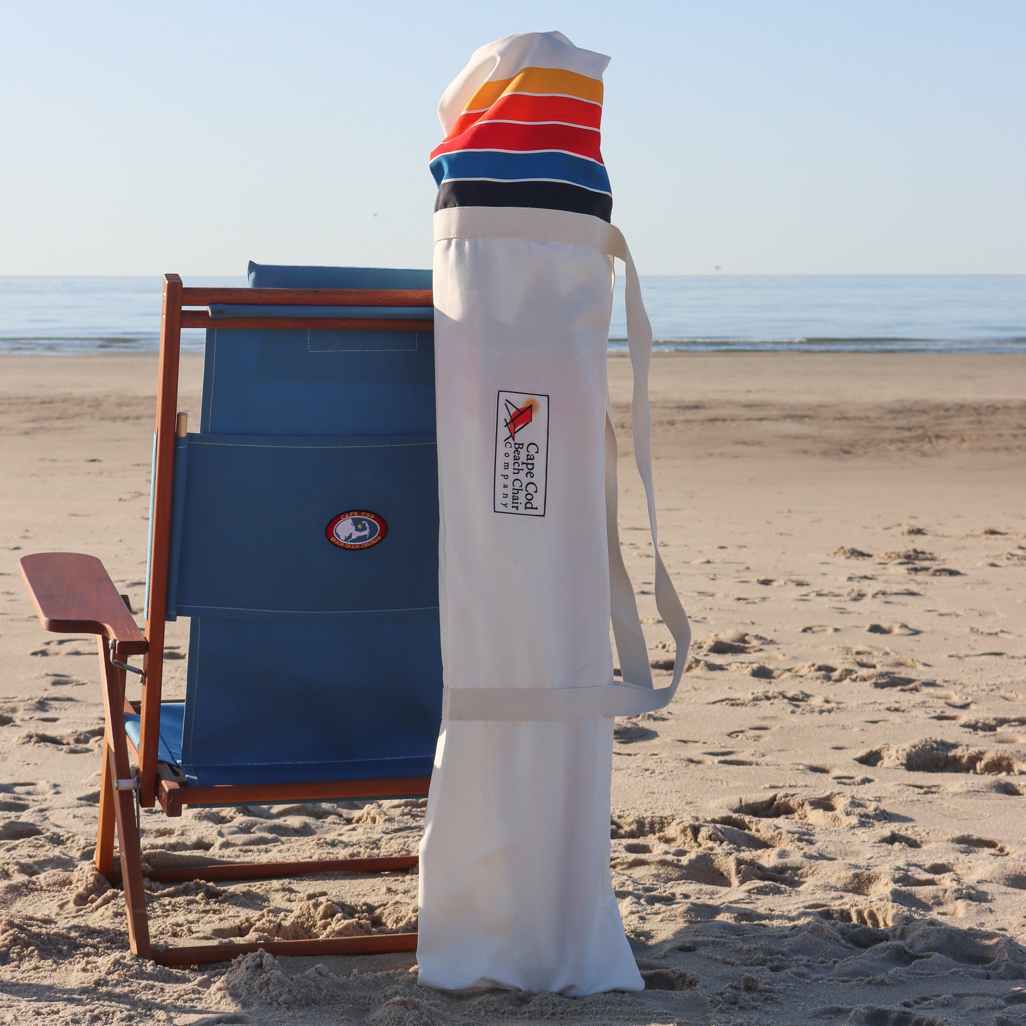 white striped beach umbrella folded in storage bag