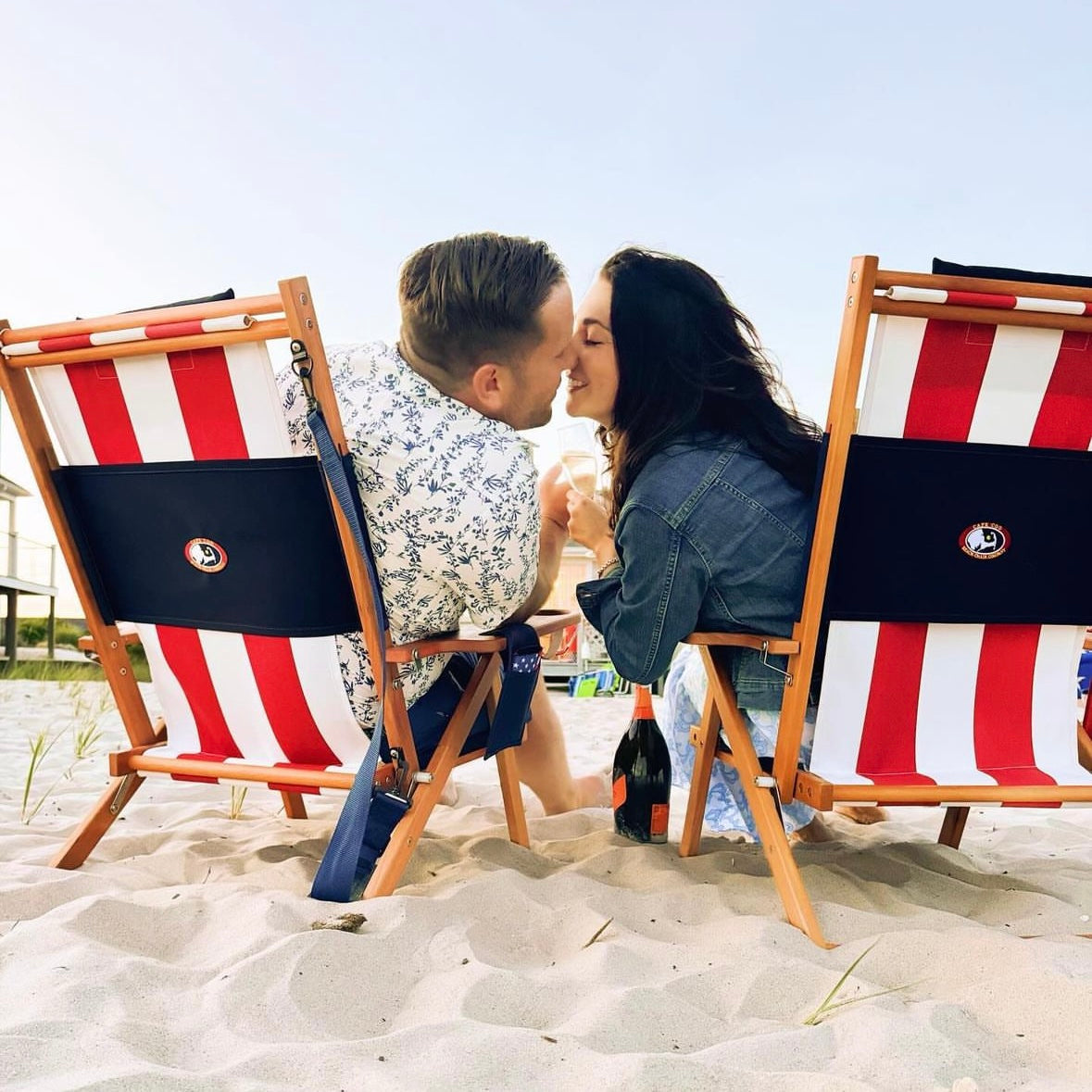 Happy Couple Sharing a Kiss in Red White and Blue Wood Beach Chairs