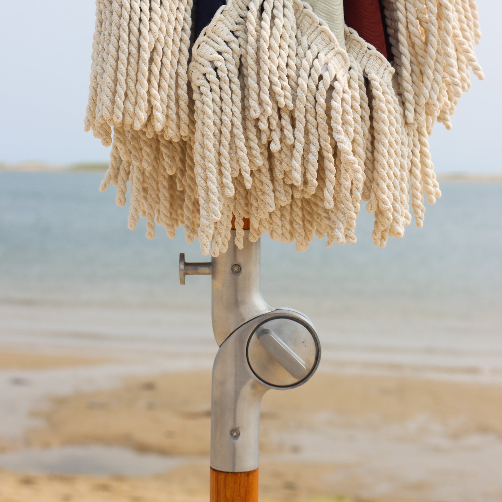 Cotton fringe on beach umbrella with metal tilt mechanism
