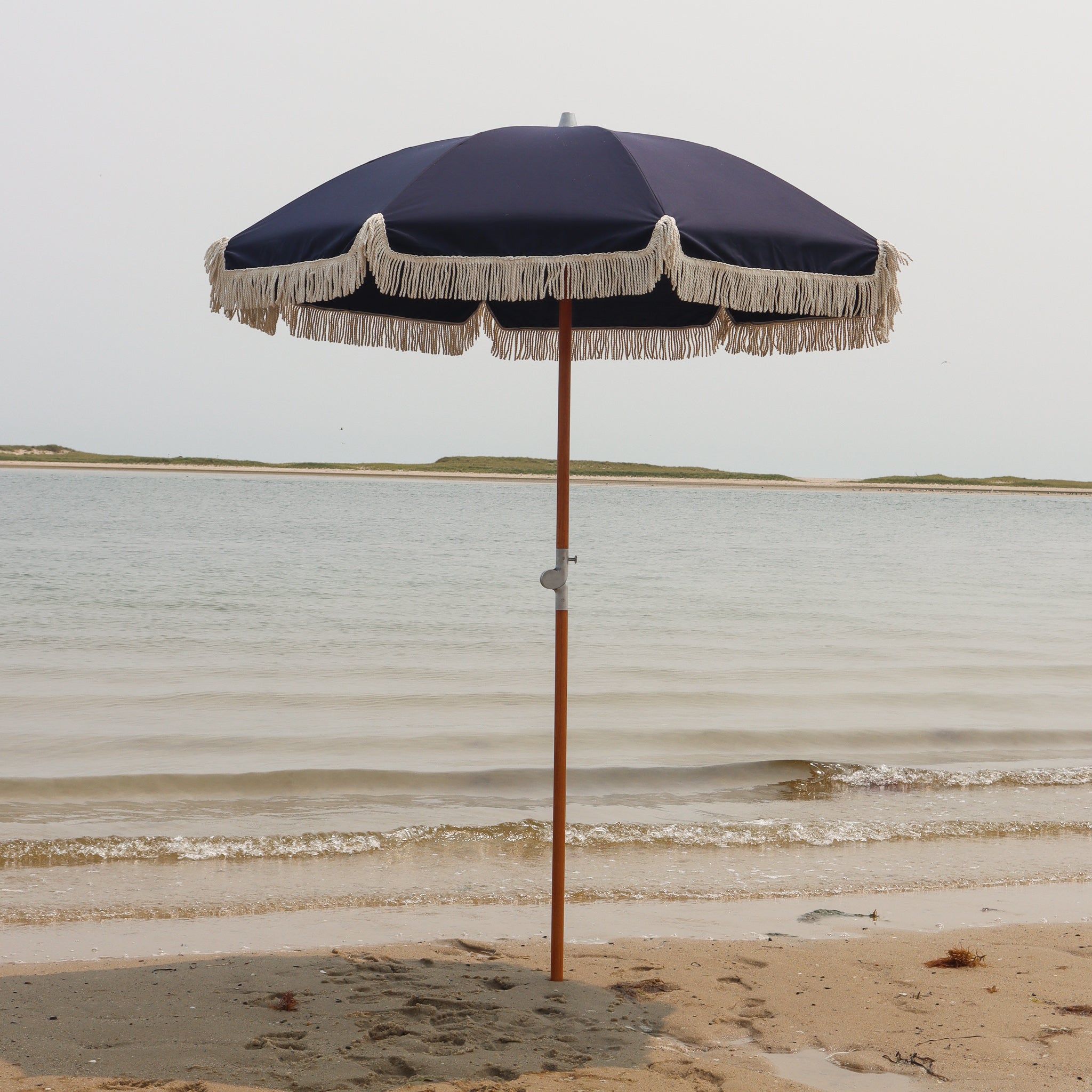 Navy blue beach umbrella with tassels on Cape Cod beach