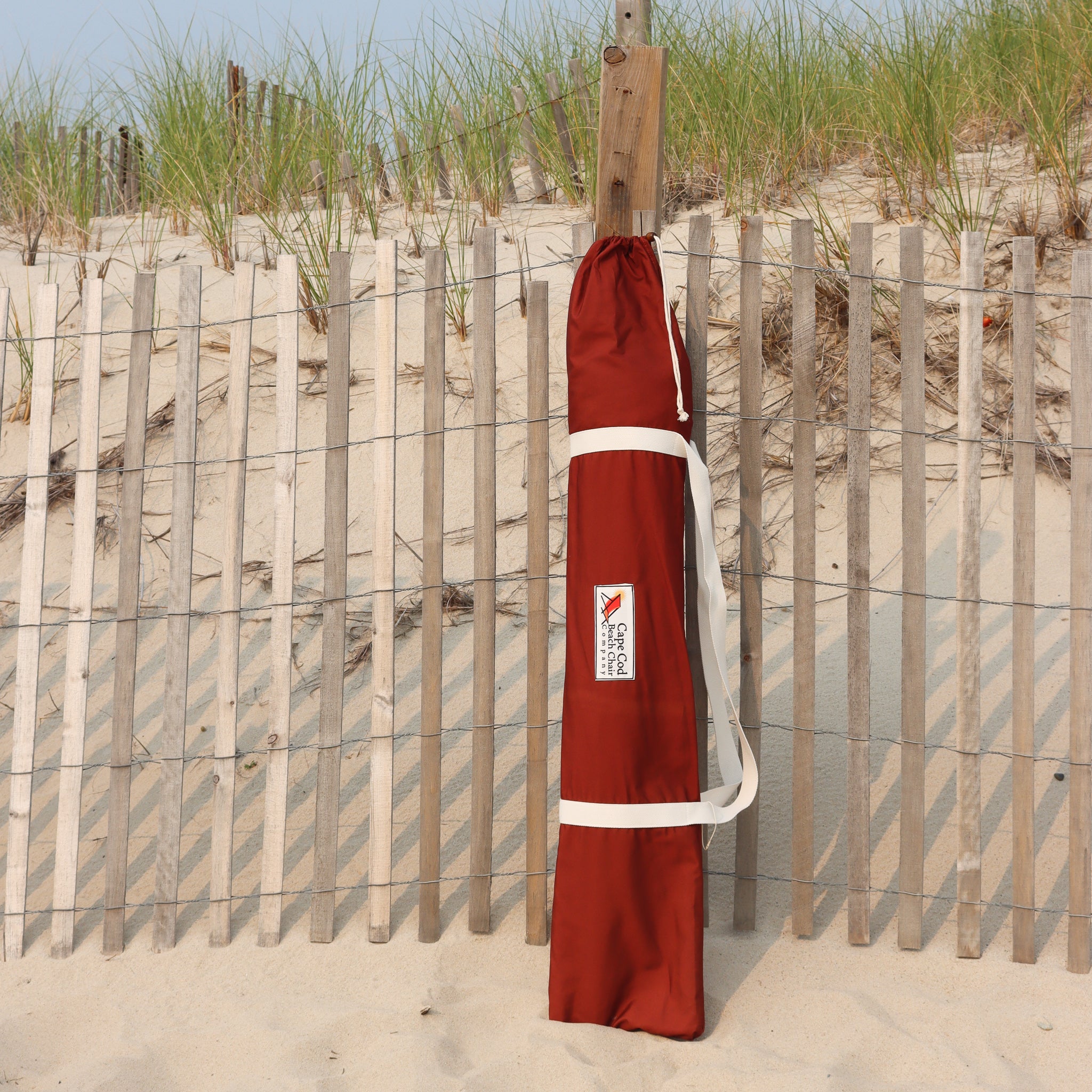 Maroon storage bag for multicolored beach umbrella