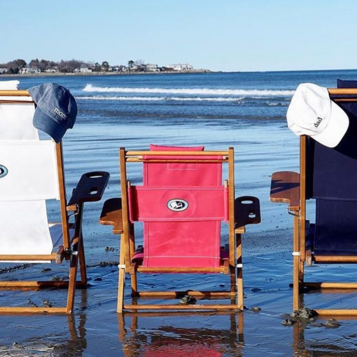 Beach chairs and surfboards on a sandy beach with ocean view