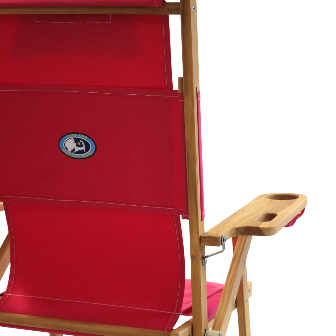 Pink folding chair with wooden armrests on a white background