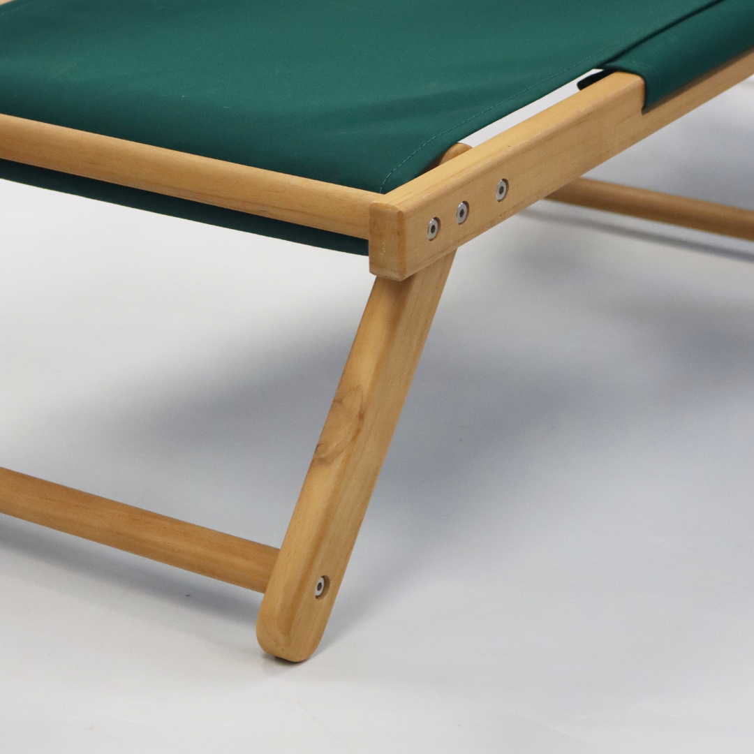 Green beach chair footrest with a wooden frame background