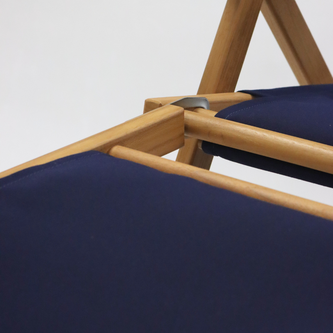 Close-up of a wooden chair with navy footrest
