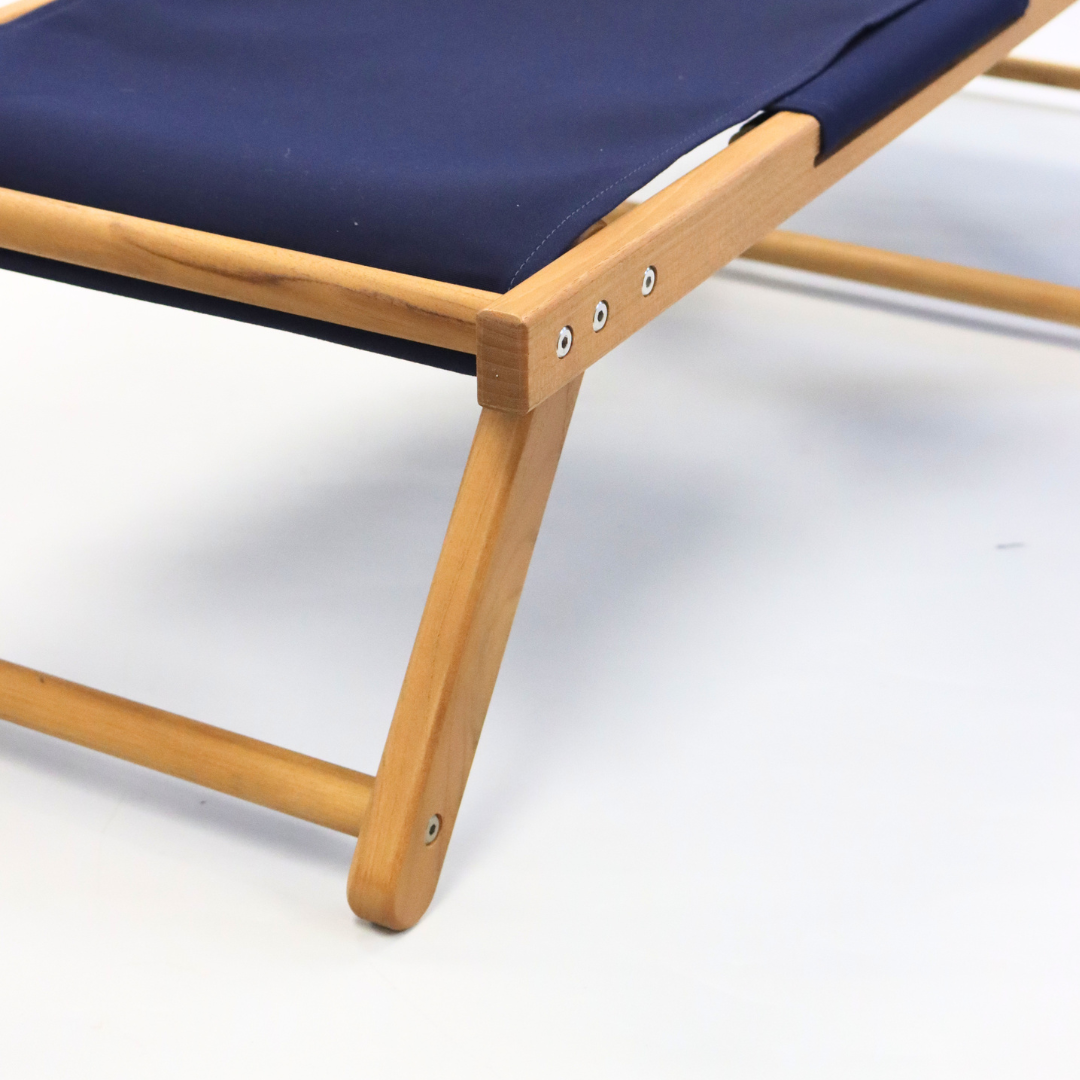 Wooden deck chair with a navy blue footrest