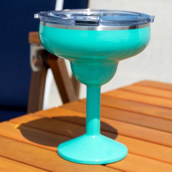 Turquoise insulated margarita drink-ware on wood beach table