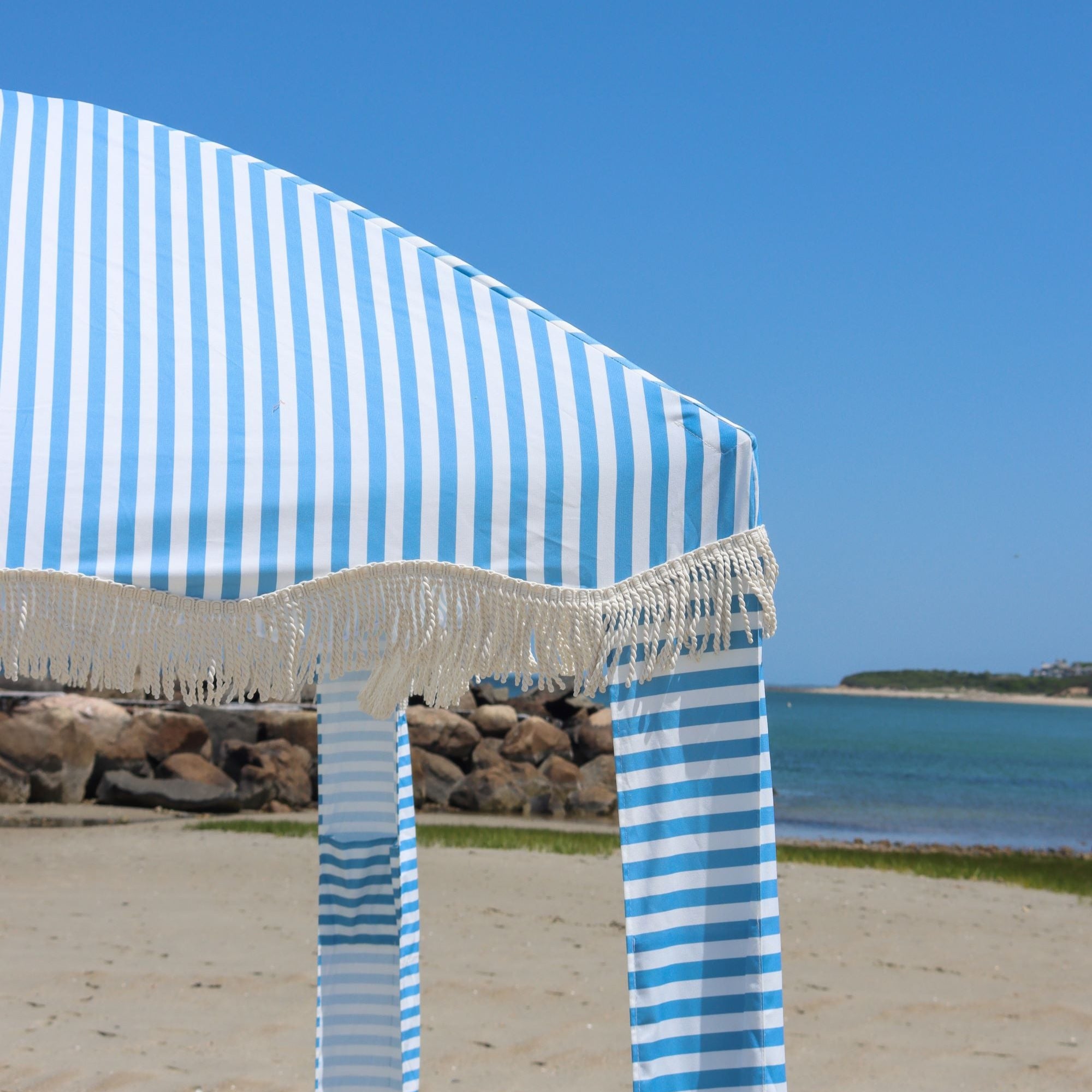 Light blue and white premium beach cabana with tassels