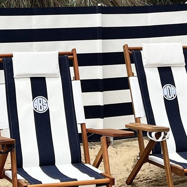 navy and white beach windscreen behind custom embroidered navy and white wooden beach chairs