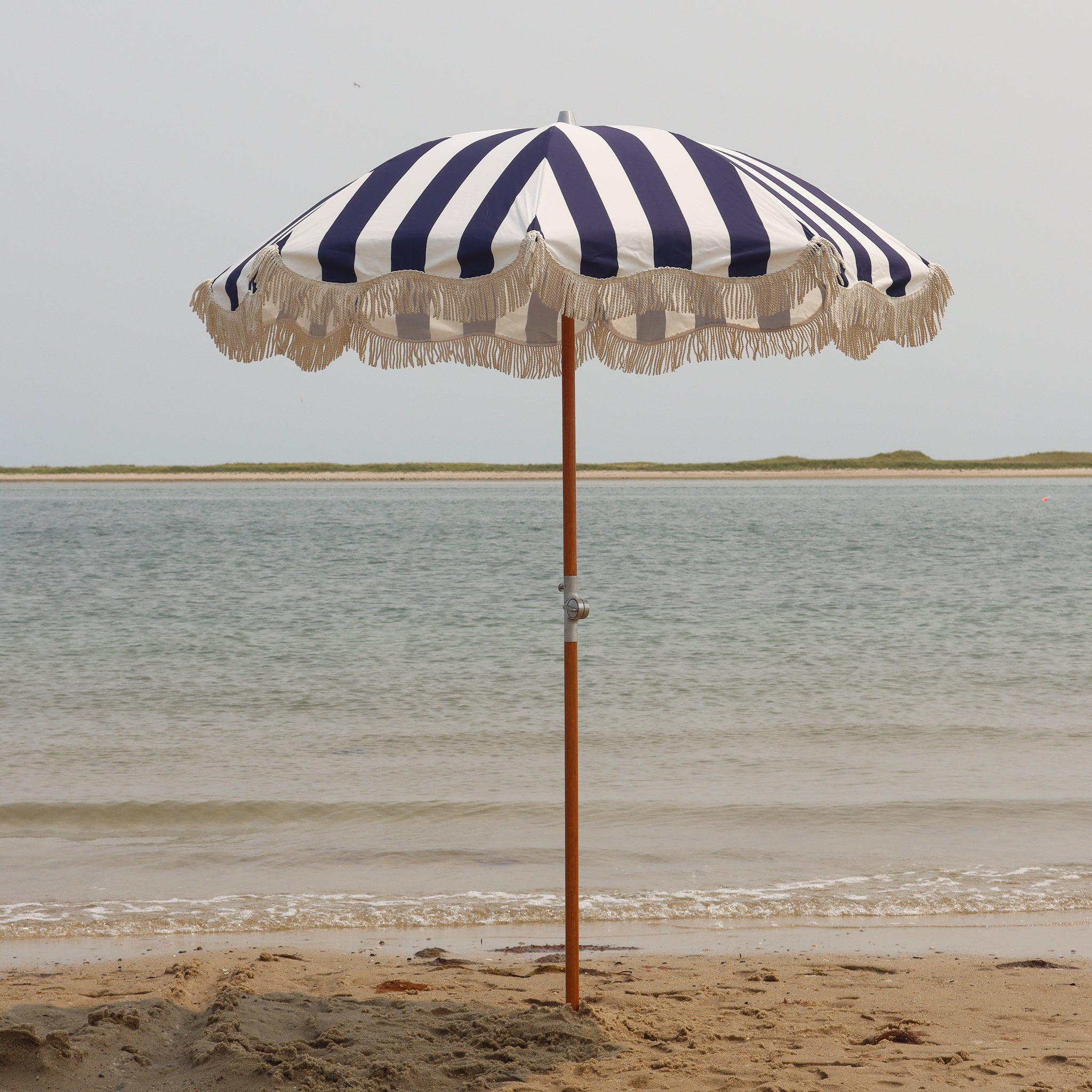 Navy and white striped beach umbrella with fringe
