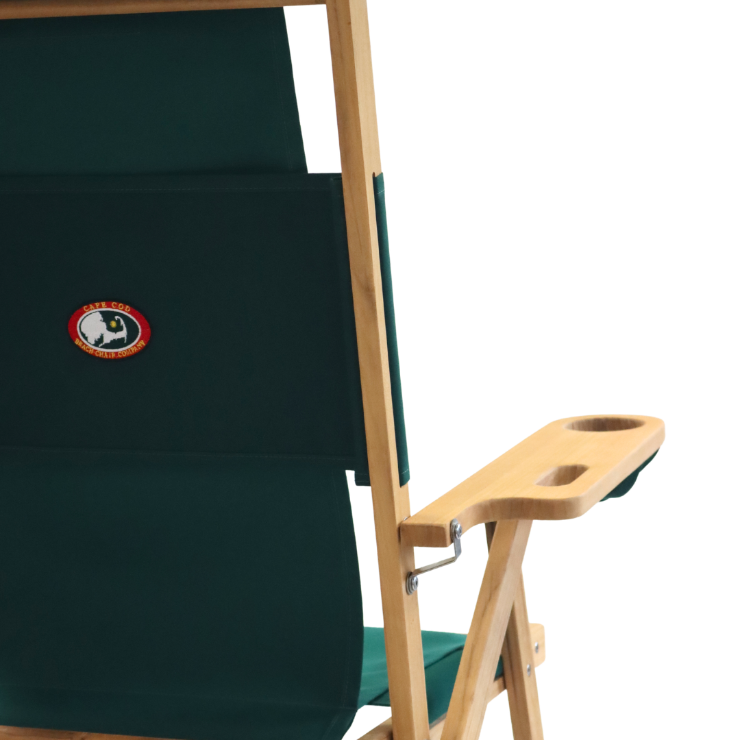 Green deck chair with wooden armrests and a cupholder