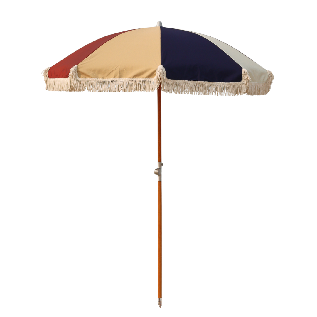 A colorful, wood poled umbrella with alternating colored panels and decorative fringe tassels.