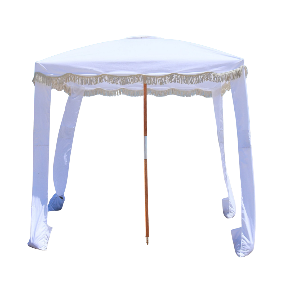 A gorgeous portable white beach cabana with tassels.