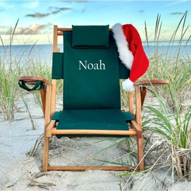 Kid's green beach chair with 'Noah' embroidered on it and a Santa hat