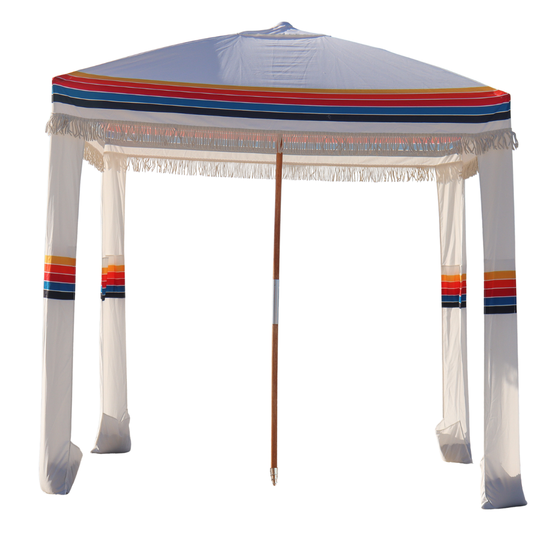 A white beach cabana with a retro. 70's inspired rainbow striped canopy.